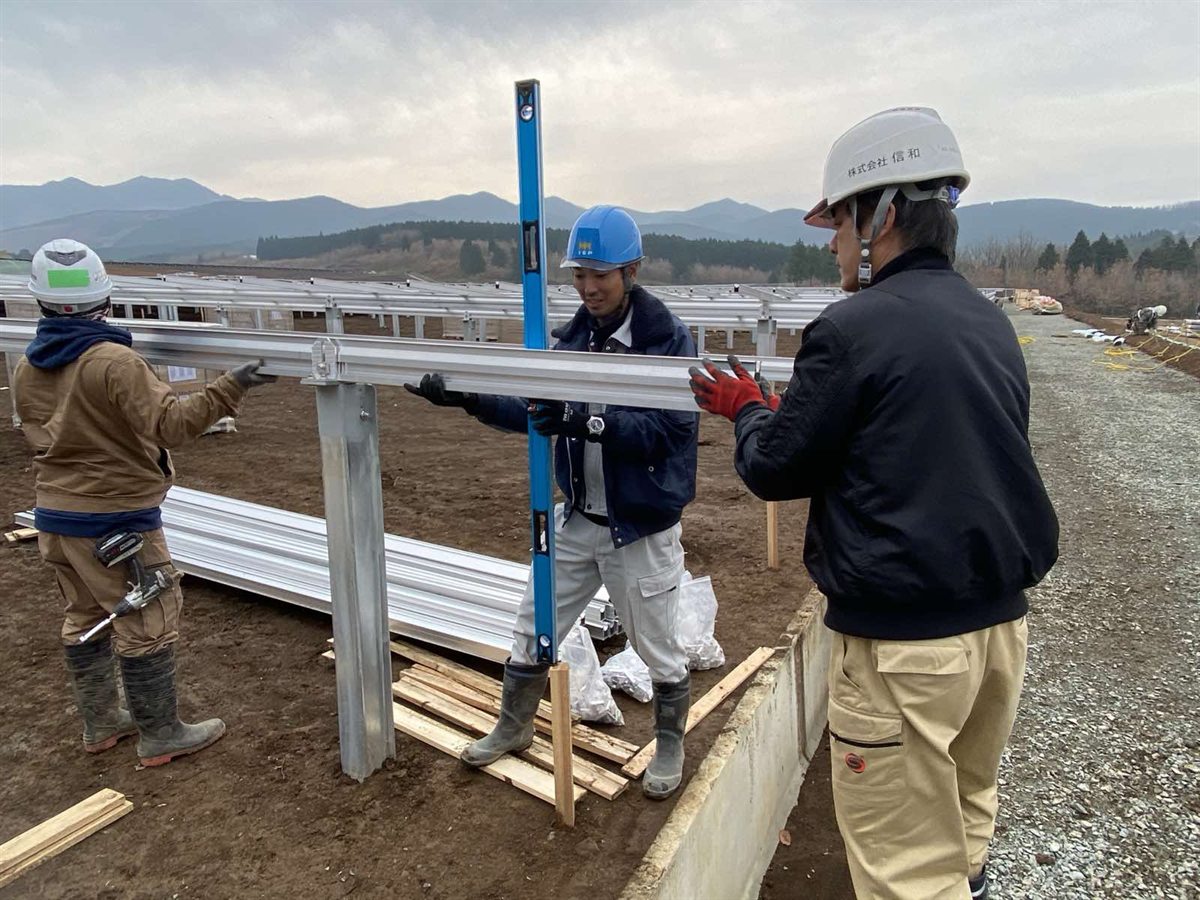 信和ヘルメットの作業員が水平器で架台をチェック